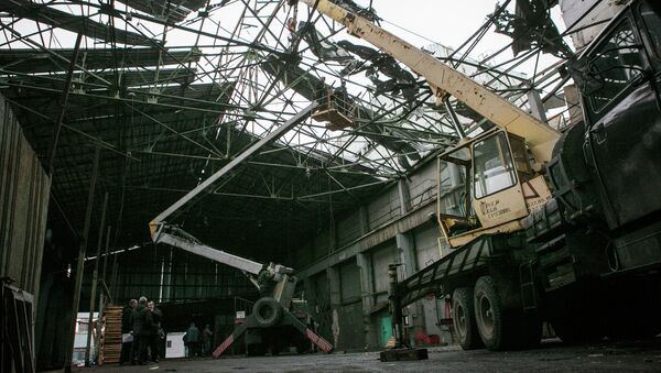 Рабочие проводят восстановительные работы в одном из цехов завода, пострадавшем в результате обстрела города Донецка