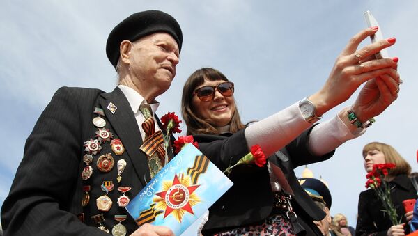 Девушка делает селфи с ветераном во время празднования 70-летия Победы в Великой Отечественной войне 1941-1945 годов в городе Казань