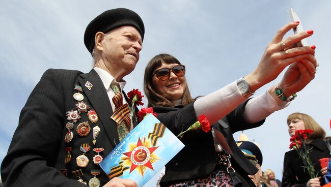 Девушка делает селфи с ветераном во время празднования 70-летия Победы в Великой Отечественной войне. Архивное фото