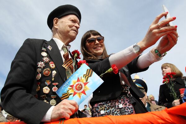 Девушка делает селфи с ветераном во время празднования 70-летия Победы в Великой Отечественной войне 1941-1945 годов в городе Казань