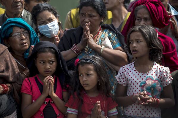 Местные жители молятся в очереди за гуманитарной помощью. Бхактапур, Непал