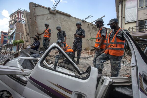 Военнослужащие стоят на разрушенном здании после новых толчков в Катманду. 12 мая 2014