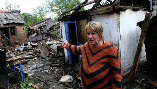 Местная жительница во дворе жилого дома, разрущенного в результате обстрелов украинскими силовиками города Горловки Донецкой области