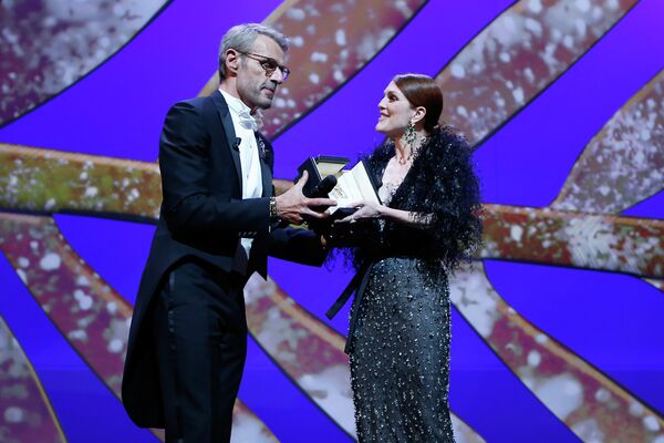 Актер Ламберт Уилсон вручает награду актрисе Джулианне Мур на церемонии открытия Каннского кинофестиваля