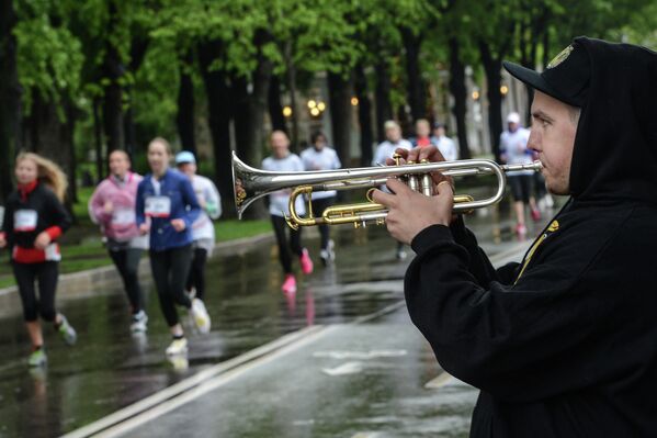 Музыкант играет на трубе во время благотворительного забега Бегущие сердца