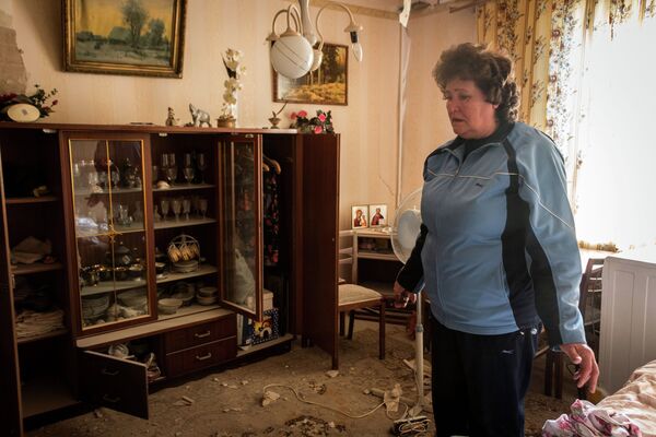 Жительница Донецка в квартире, поврежденной в результате обстрела украинскими силовиками