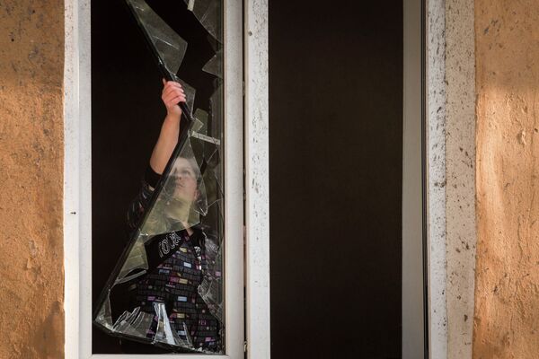 Жительница Донецка в квартире, поврежденной в результате обстрела украинскими силовиками