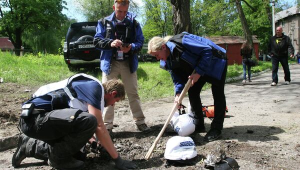 Сотрудники миссии ОБСЕ у дома, разрушенного в результате обстрела украинскими силовиками в Донецке