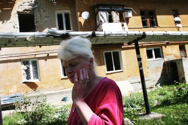 Жительница Донецка у дома, разрушенного в результате обстрела украинскими силовиками
