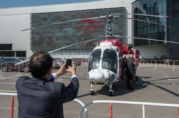 Посетитель фотографирует вертолет КА-226Т на HeliRussia 2015