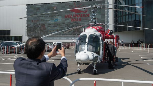 Посетитель фотографирует вертолет КА-226Т на HeliRussia 2015. Архивное фото