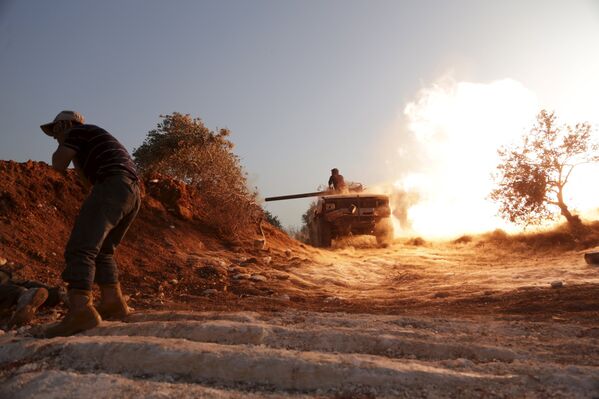 Боец группировки Аль-Фуркан ведет бой за военную базу недалеко от города Идлиб, Сирия
