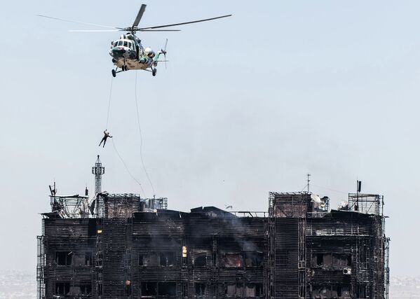 Спасатель спускается с вертолета на крышу жилого дома в Баку, в котором произошел пожар