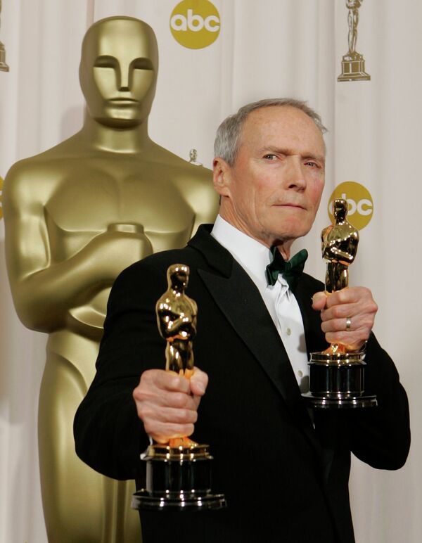 Американский актер и режиссер Клинт Иствуд позирует с статуэтками Оскара