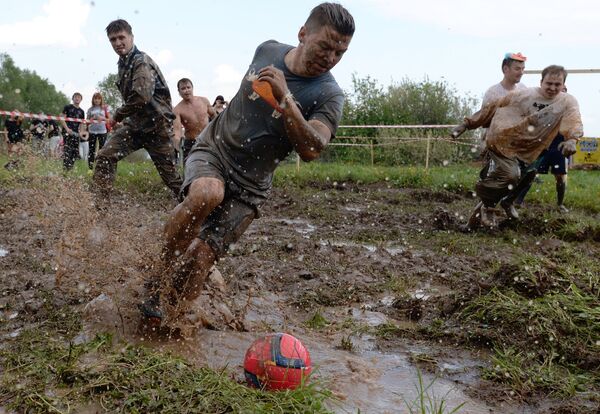 Участники матча Футбола в грязи, который проводится в рамках соревнований Грязный забег - 2015 в Казани
