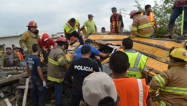 Полиция и пожарные осматривают обломки школьного автобуса после торнадо в Мексике