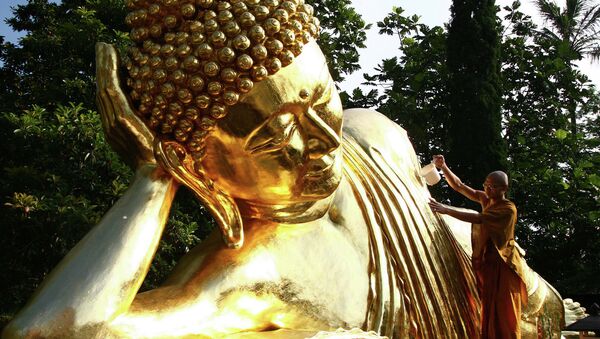 Монах у статуи Будды. Архивное фото