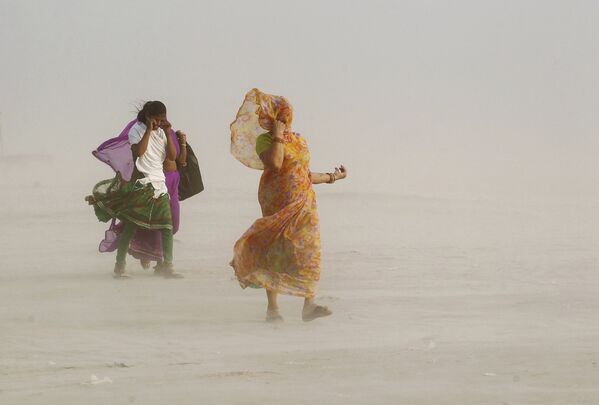 Женщины на берегу реки Ганк во время пыльной бури в Аллахабаде. Индия, 2015 год