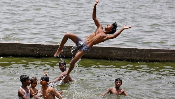 Мальчики спасаются от жары в реке Сабармати. Ахмедабаде, Индия, май 2015