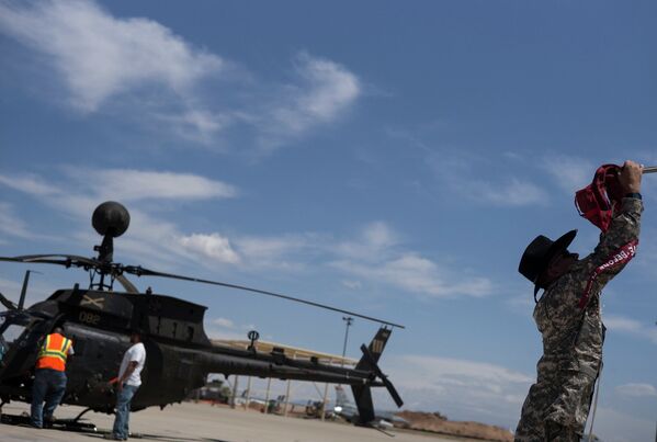 Военнослужащий зачехляет лопасти вертолета OH-58 Kiowa на авиабазе ВВС США Девис-Монтен в Тусоне, Аризона