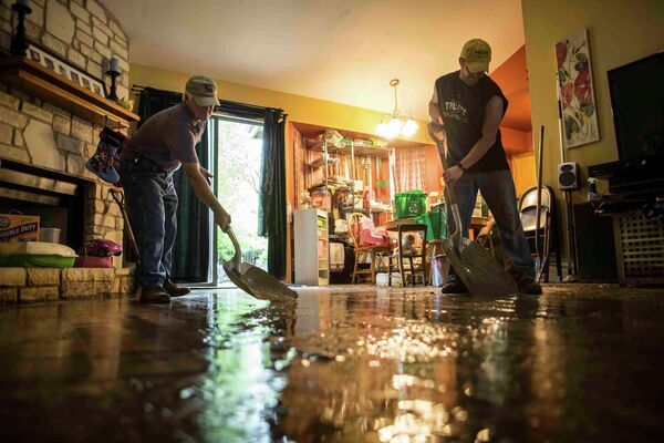 Волонтеры помогают с уборкой дома, поврежденного в результате наводнения в Техасе, США
