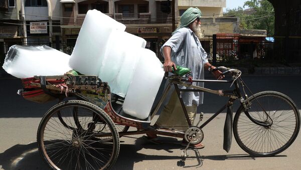 Индийский рабочий перевозит куски льда в велорикше. Амритсар, Индия, май 2015. Архивное фото
