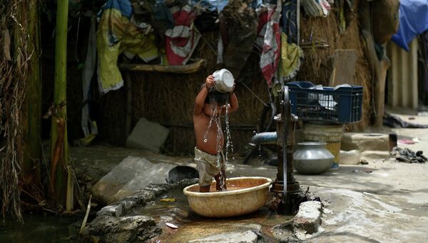 Мальчик обливается водой во время аномальной жары в Нью-Дели, Индия