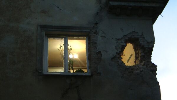 Ночной обстрел Донецка: дыра в стене дома и застрявший в асфальте снаряд