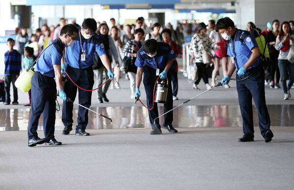 Работнки проводят дезинфекцию в международном аэропорту Инчхон во время вспышки вируса MERS в Южной Корее