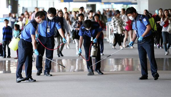 Работнки проводят дезинфекцию в международном аэропорту Инчхон во время вспышки вируса MERS в Южной Корее. Архивное фото