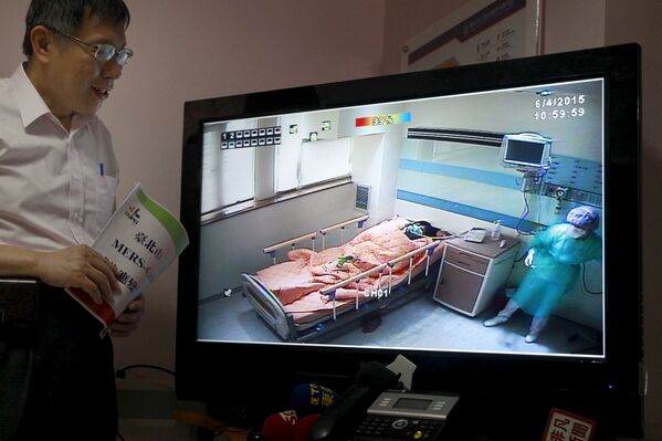 Мэр Тайбэя Ко Вэнь-Цзе смотрит на экран с изображением изолятора для госпитализации заразившихся вирусом MERS, Тайвань