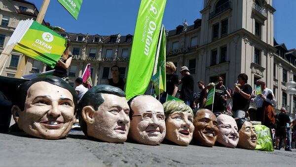 Участники акции протеста в Мюнхене приуроченной к саммиту G-7 с муляжами голов мировых лидеров