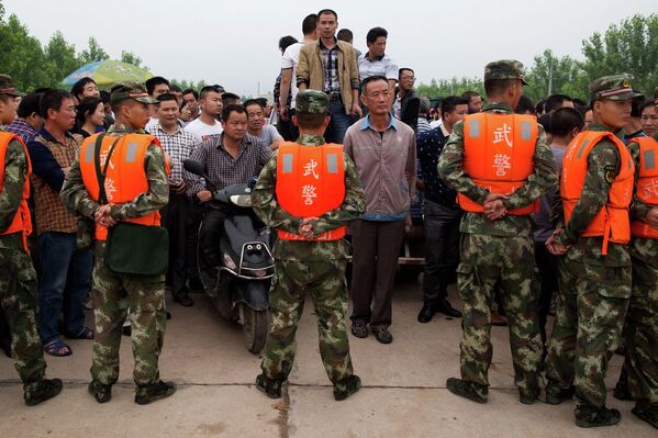 Сотрудники китайской военизированной полиции охраняют место проведения спасательных работ у реки Янцзы