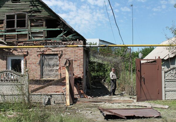 Местный житель во дворе частного жилого дома, разрушенного в результате обстрела Октябрьского района города Донецка