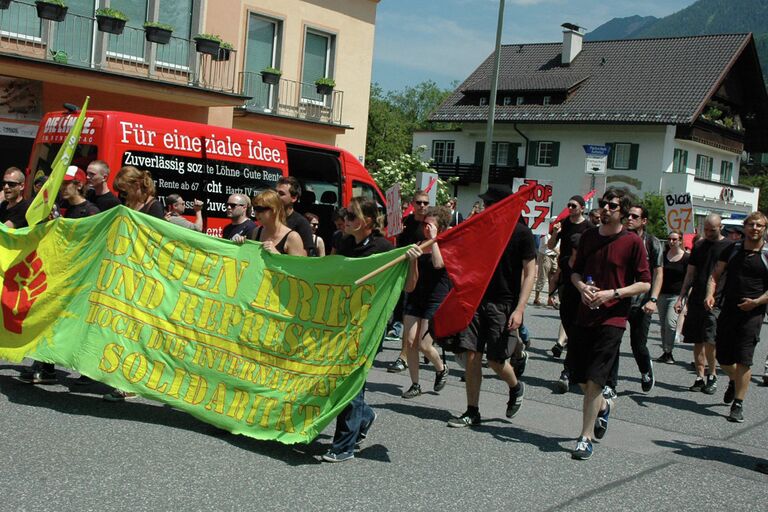 Участники акции протеста против саммита G-7 перед началом шествия по улицам города Гармиш-Партенкирхена