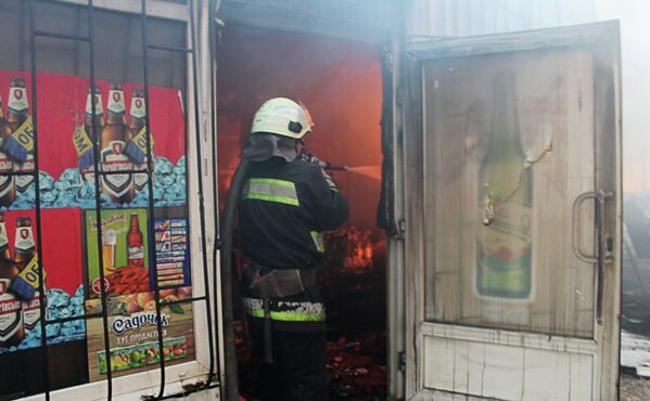 Сотрудник пожарной охраны во время тушения пожара на рынке Октябрьский в Донецке