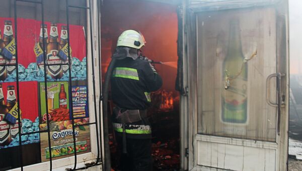 Сотрудник пожарной охраны во время тушения пожара на рынке Октябрьский в Донецке