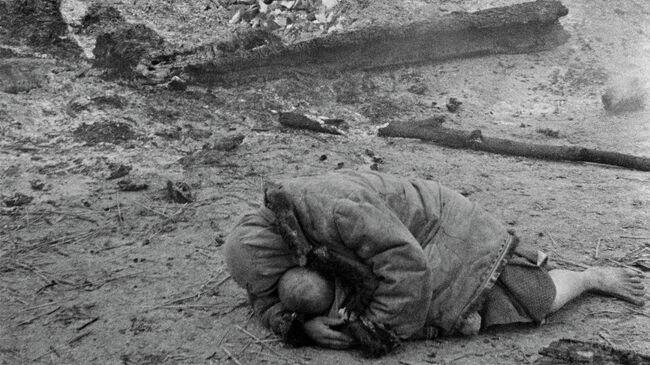 Мать укрывает своего ребенка во время обстрела. Деревня Красная слобода, Брянский фронт 1941 год Мать укрывает своего ребенка во время обстрела. Деревня Красная слобода, Брянский фронт 1941 год