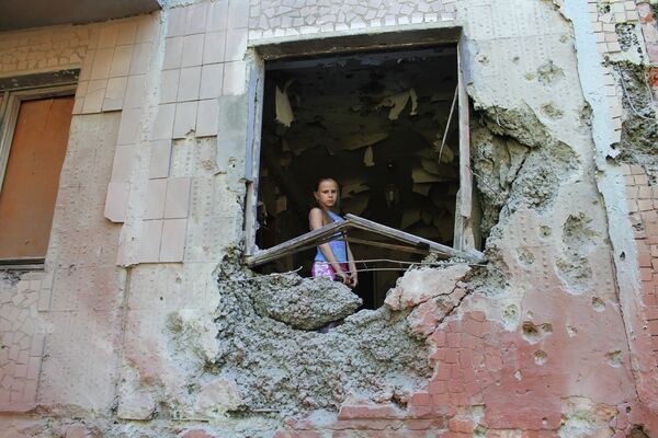 Девочка в пострадавшей квартире жилого дома, разрушенного в результате обстрела украинскими силовиками в Горловке