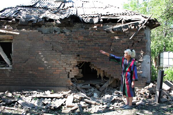 Женщина у дома, пострадавшего в результате обстрела украинскими силовиками в Горловке