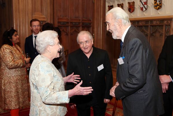 Королева Великобритании Елизавета II общается с актером Кристофером Ли