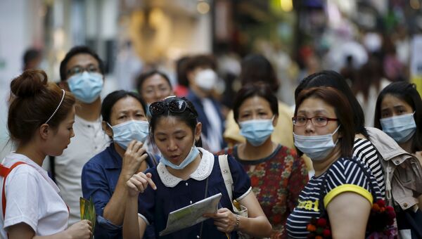Люди в медицинских масках в центре Сеула, 12 июня 2015