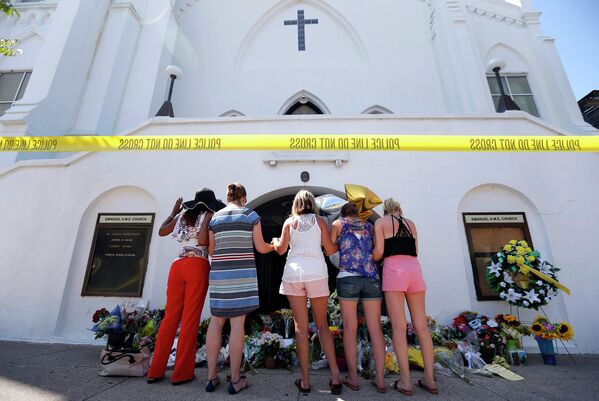 Люди, пришедшие почтить память погибших во время стрельбы в африканской методистской епископальной церкви Эмануэль города Чарлстон, США