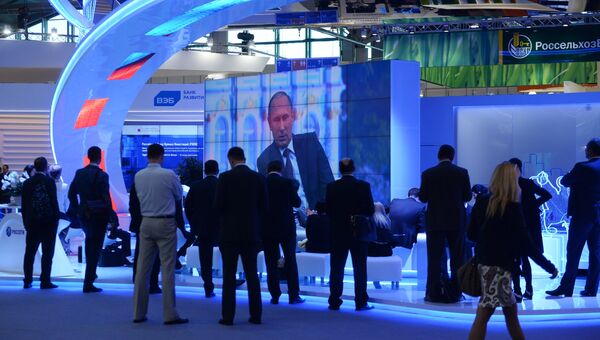 Участники XIX Петербургского экономического форума смотрят трансляцию выступления президента РФ Владимира Путина на панельной дискуссии в ходе пленарного заседания ПМЭФ
