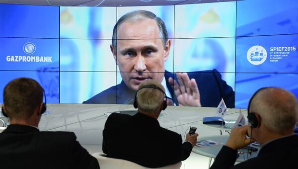 Участники XIX Петербургского международного экономического форума смотрят трансляцию выступления президента РФ Владимира Путина на панельной дискуссии в ходе пленарного заседания ПМЭФ