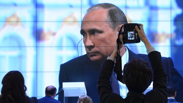 Участники XIX Петербургского международного экономического форума смотрят трансляцию выступления президента РФ Владимира Путина на панельной дискуссии в ходе пленарного заседания ПМЭФ