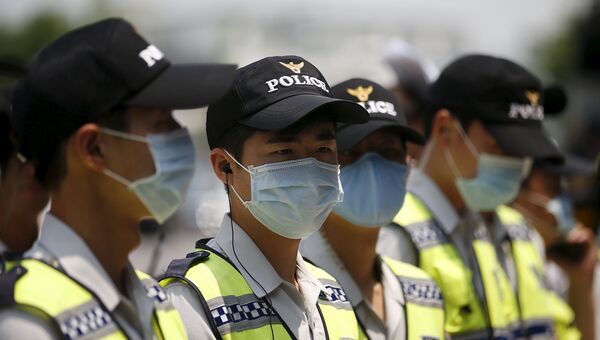 Полицейские в масках у здания посольства Японии в Сеуле. Июнь 2015