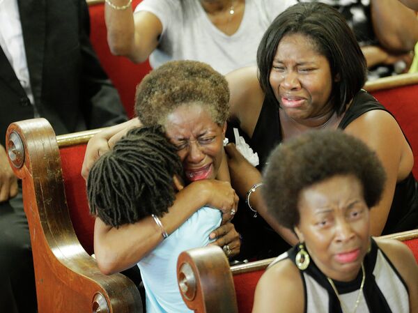 Прихожане молятся и плачут во время службы в церкви в Чарльстоне