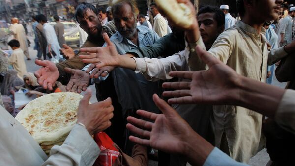 Раздача хлеба беднякам во время священного месяца Рамадан в Пешаваре, Пакистан. Архивное фото