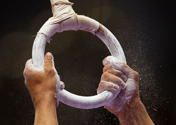 Спортсмен выполняет упражнения на кольцах на соревнованиях по спортивной гимнастике на I Европейских играх в Баку